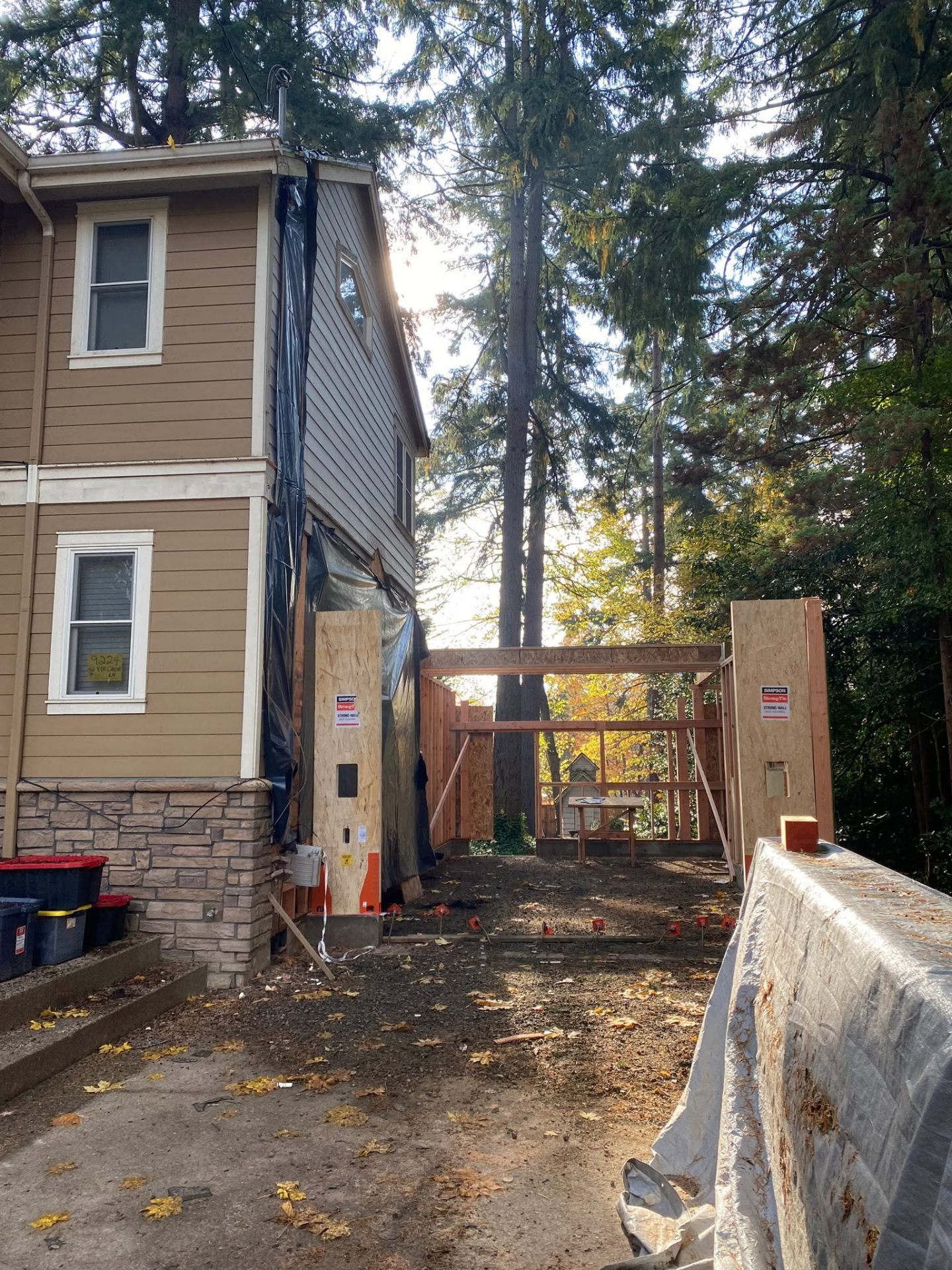 Framed addition on a fresh concrete foundation between homes